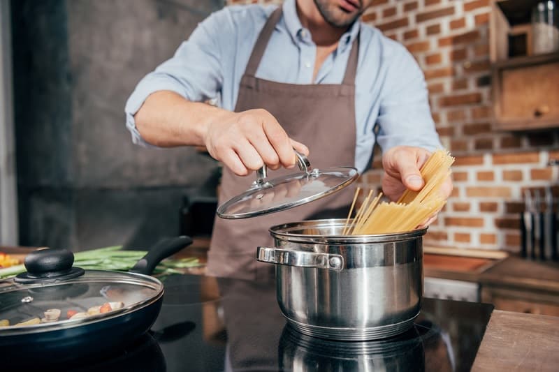 Man Cooking Spaghetti in Saucepan