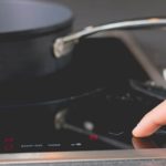 Finger touching button on induction hob