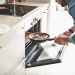 Man putting pan in oven
