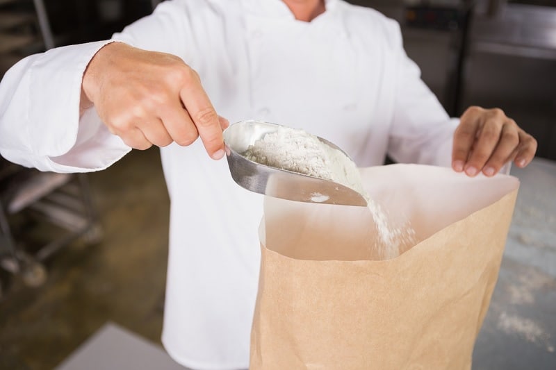 Baker taking flour out of bag