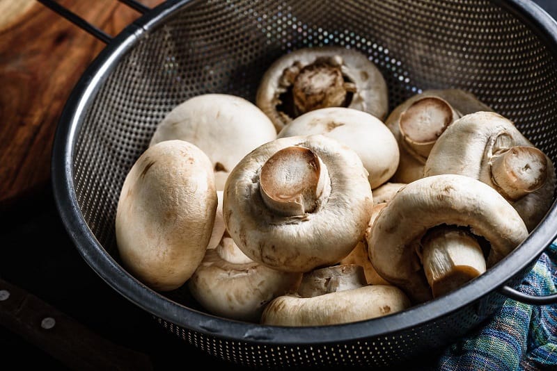 Button mushrooms in colander
