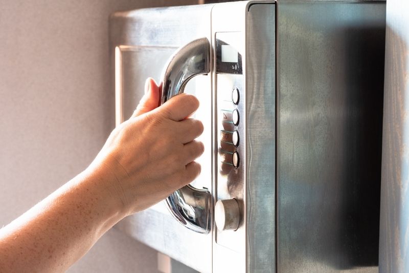 Person's hand holding the oven's handle