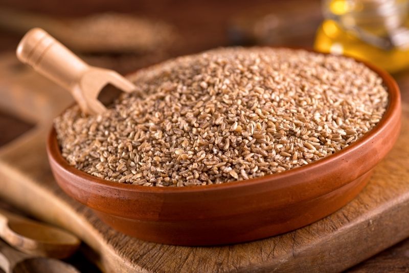 Uncooked Bulgar Wheat  in wooden pan