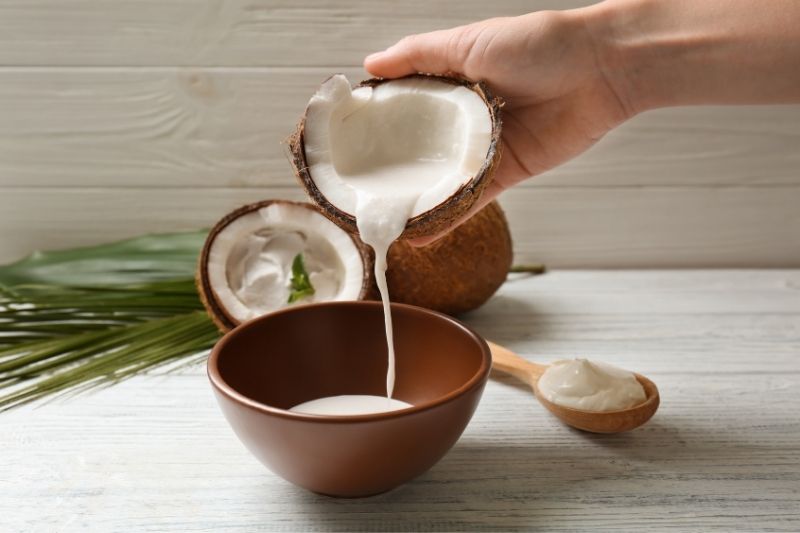 person's hand pouring coconut cream