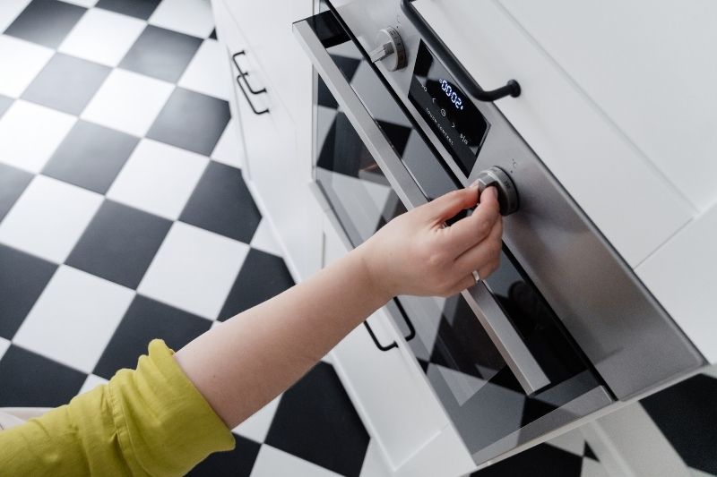 Person's hand operating the oven