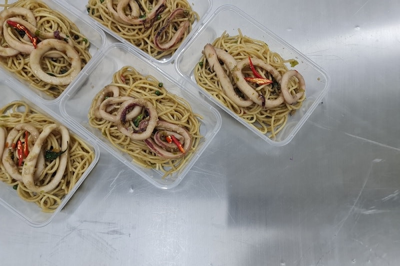 Stir fried squid in plastic tubs